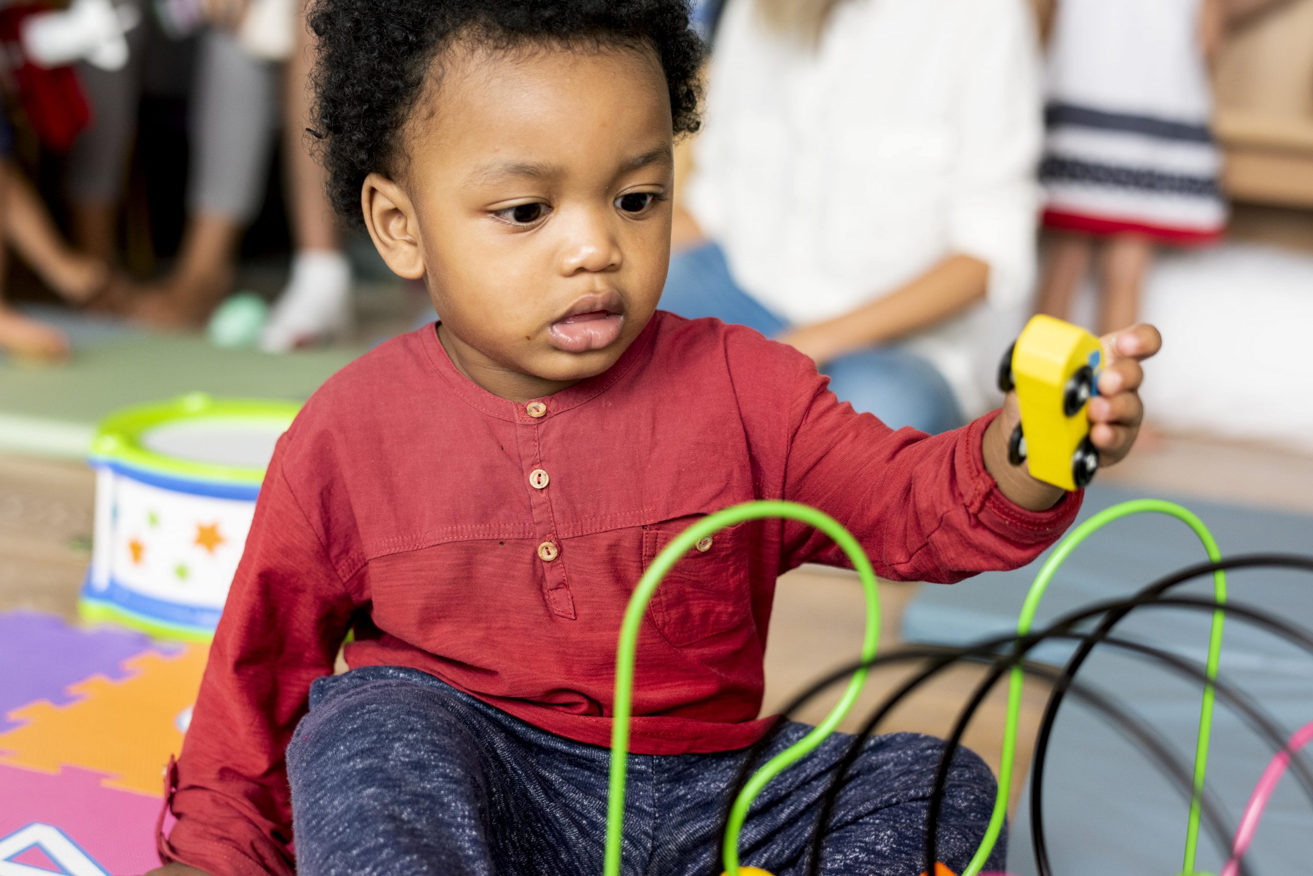 little-boy-playing-toys-playroom-min